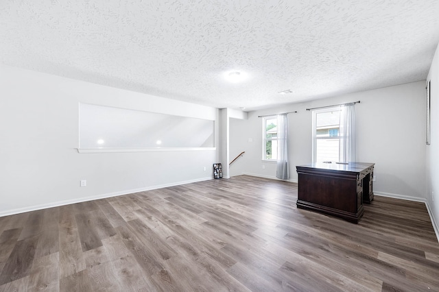 unfurnished room with a textured ceiling and hardwood / wood-style flooring