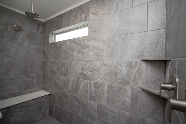 bathroom with crown molding and tiled shower