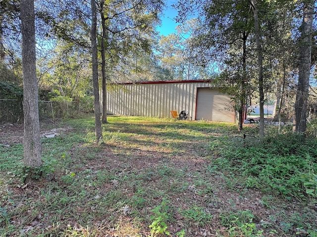 view of yard with a garage and an outbuilding