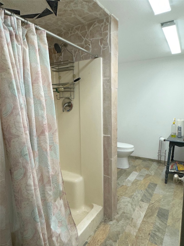 bathroom with toilet and a shower with curtain