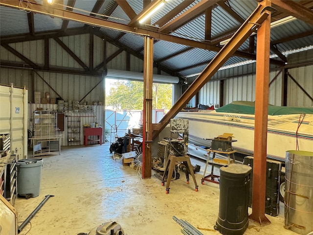 interior space featuring concrete floors, wood walls, and vaulted ceiling