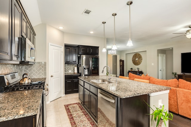 kitchen featuring appliances with stainless steel finishes, ceiling fan, a kitchen island with sink, sink, and hanging light fixtures