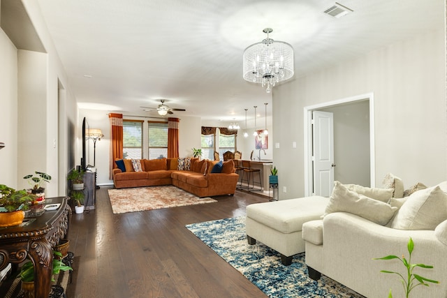 living room with ceiling fan with notable chandelier and dark hardwood / wood-style flooring