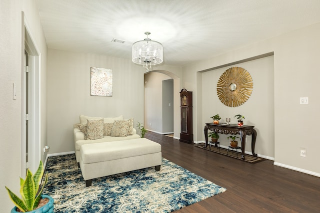 sitting room featuring a chandelier and dark wood-type flooring