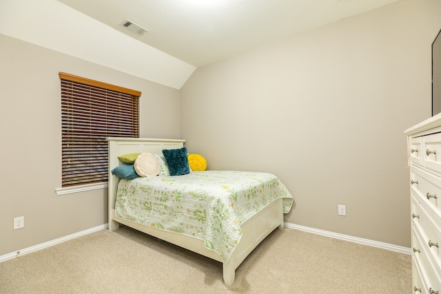 bedroom featuring light carpet and vaulted ceiling