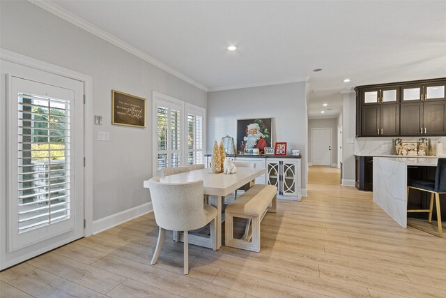 dining area featuring ornamental molding and light hardwood / wood-style flooring