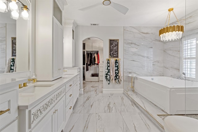 bathroom with ceiling fan, a bathtub, and vanity