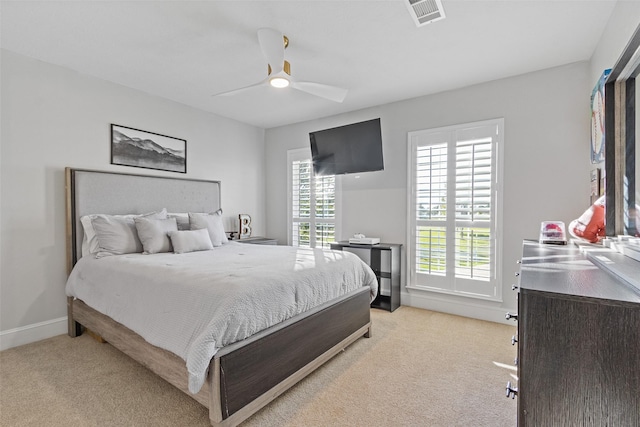 carpeted bedroom with ceiling fan and multiple windows