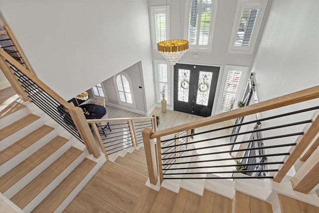 entrance foyer with french doors, a healthy amount of sunlight, and hardwood / wood-style flooring