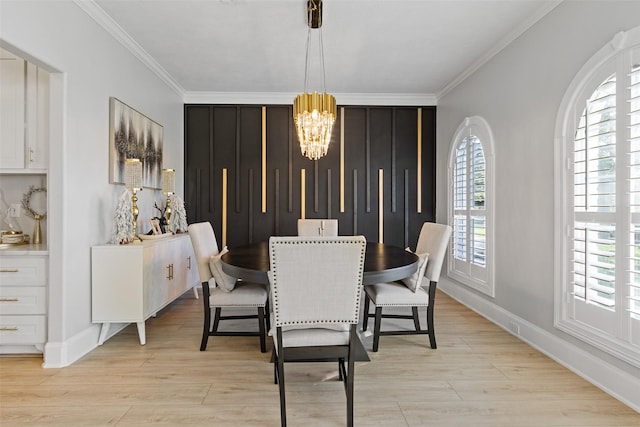 dining space with a chandelier, light hardwood / wood-style floors, and ornamental molding