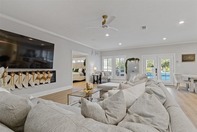 living room featuring french doors, light hardwood / wood-style floors, ceiling fan, and ornamental molding