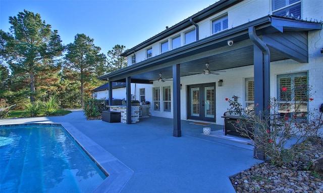 view of swimming pool with french doors, a patio, ceiling fan, and exterior kitchen