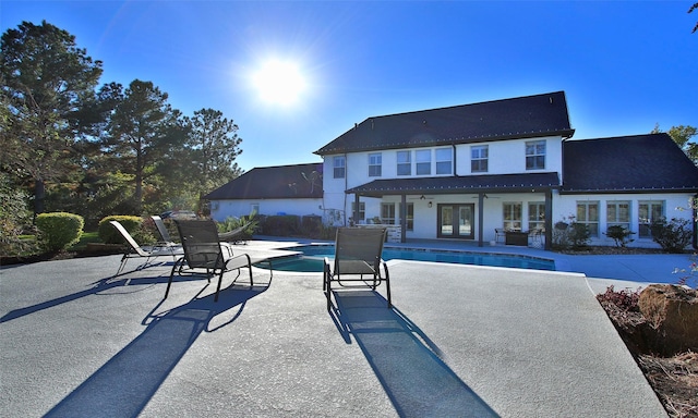 view of pool featuring french doors, ceiling fan, and a patio area