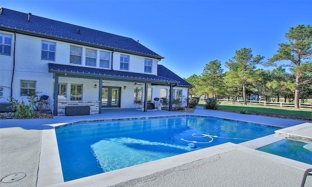 view of swimming pool with ceiling fan, a patio area, and french doors