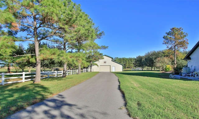 view of yard with a garage and an outbuilding