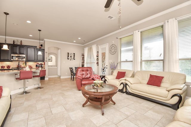 tiled living room with ceiling fan and crown molding