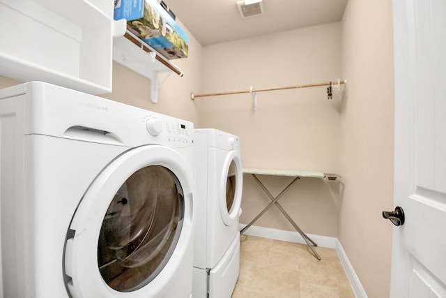 laundry room with washer and clothes dryer and light tile patterned flooring