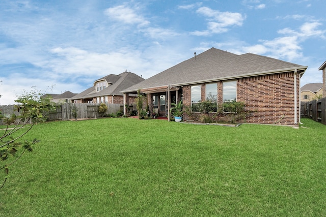 rear view of house featuring a yard