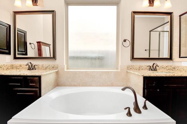 bathroom featuring vanity and tiled bath