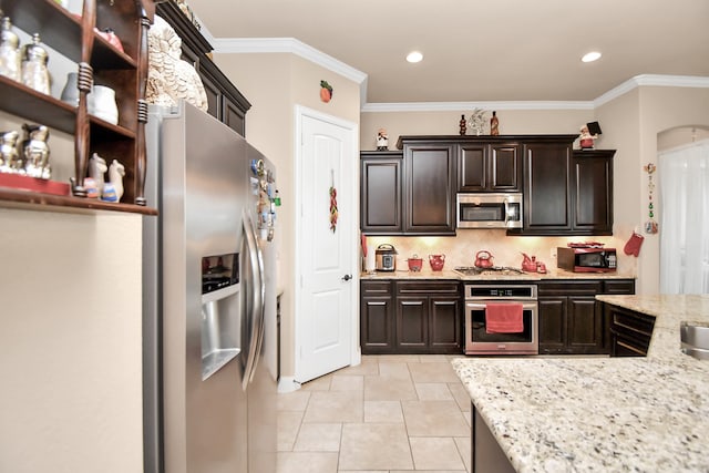 kitchen with backsplash, light stone countertops, ornamental molding, appliances with stainless steel finishes, and dark brown cabinetry