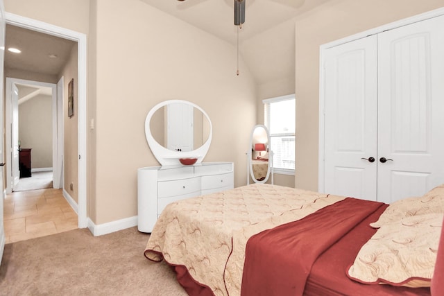 carpeted bedroom with ceiling fan, a closet, and lofted ceiling