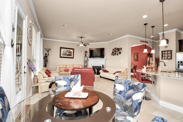 tiled dining area featuring crown molding, sink, and ceiling fan