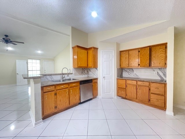 kitchen with dishwasher, sink, tasteful backsplash, vaulted ceiling, and light tile patterned flooring