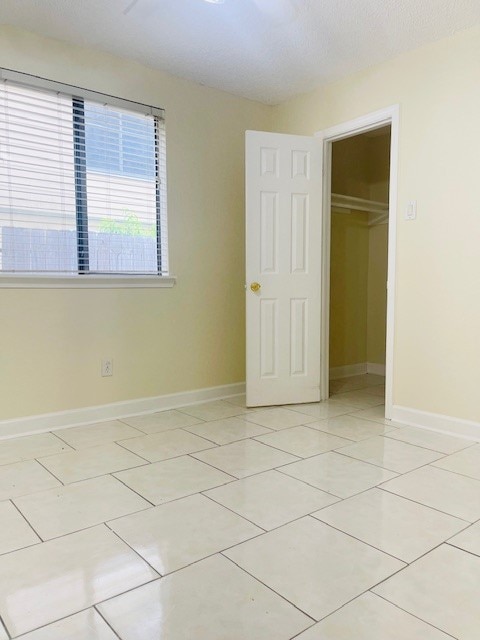 unfurnished bedroom with a closet and light tile patterned floors