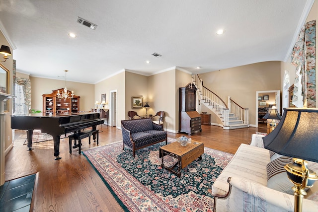 living room with ornamental molding, a textured ceiling, and hardwood / wood-style flooring