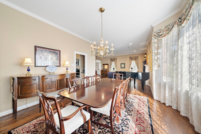 dining area featuring an inviting chandelier, wood-type flooring, and ornamental molding