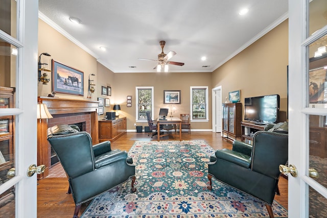 living room with light hardwood / wood-style floors, crown molding, and a fireplace