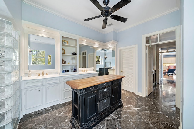 kitchen with sink, ornamental molding, butcher block countertops, a kitchen island, and white cabinetry