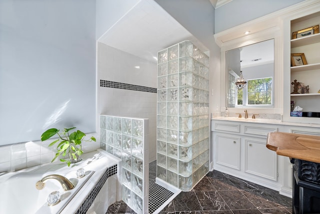 bathroom with built in features, vanity, and separate shower and tub