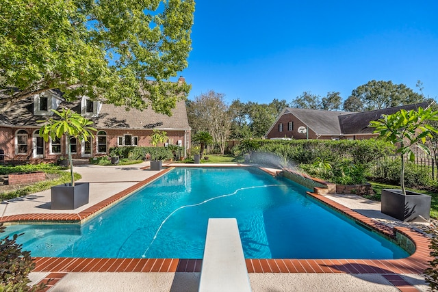 view of pool with a patio area and a diving board