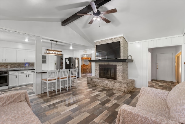 living room featuring ceiling fan, a brick fireplace, vaulted ceiling with beams, and dark hardwood / wood-style flooring