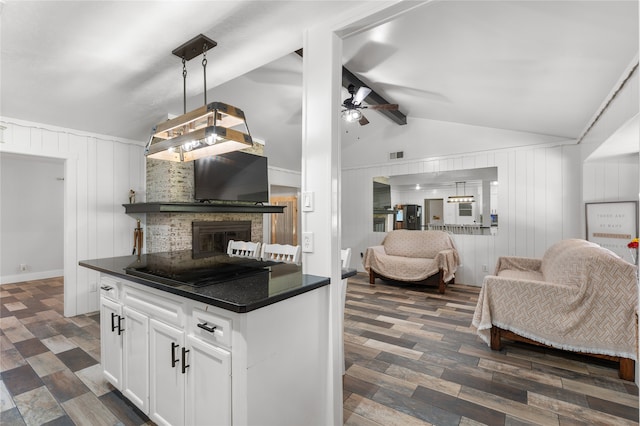 kitchen with white cabinetry, dark wood-type flooring, vaulted ceiling with beams, pendant lighting, and a fireplace