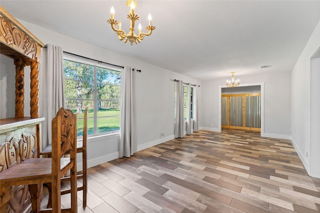 unfurnished dining area with plenty of natural light, hardwood / wood-style floors, and a notable chandelier