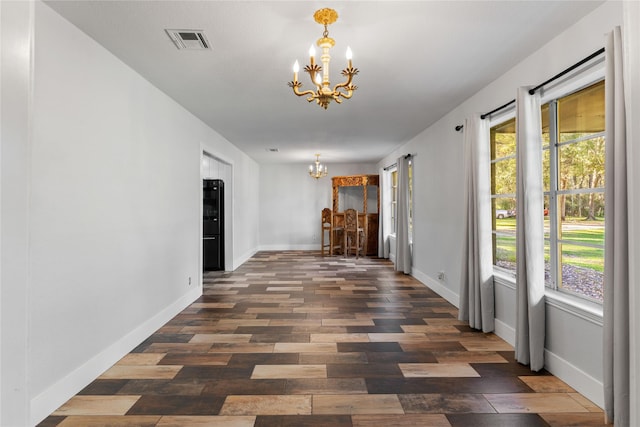 corridor with a notable chandelier and dark hardwood / wood-style flooring