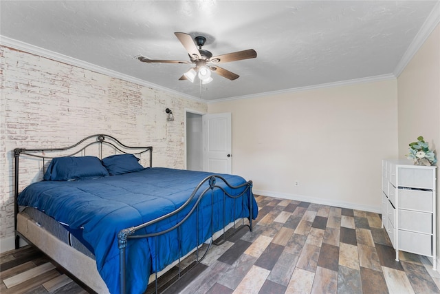 bedroom featuring dark wood-type flooring, crown molding, a textured ceiling, ceiling fan, and brick wall