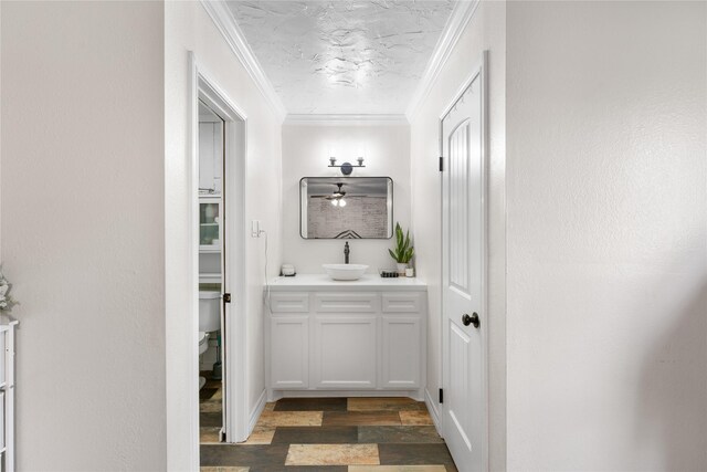 bathroom with hardwood / wood-style flooring, vanity, toilet, and ornamental molding