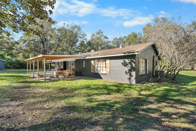 rear view of property featuring a yard and a patio area