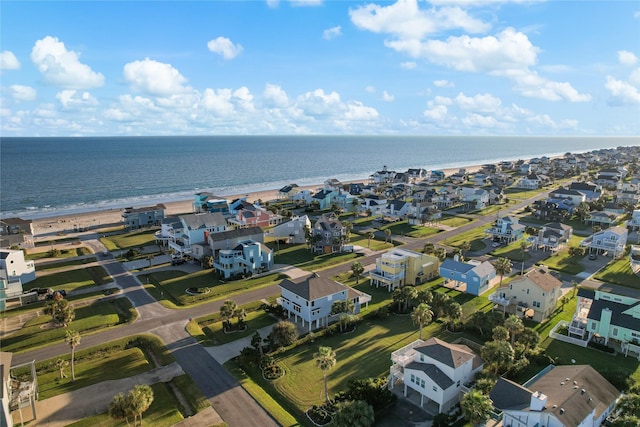 drone / aerial view featuring a residential view, a water view, and a beach view