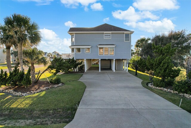 beach home featuring a front yard and a carport