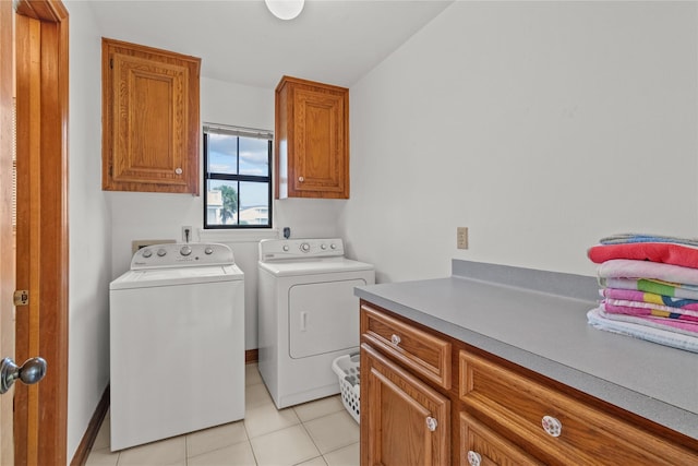 laundry room with light tile patterned floors, independent washer and dryer, and cabinet space