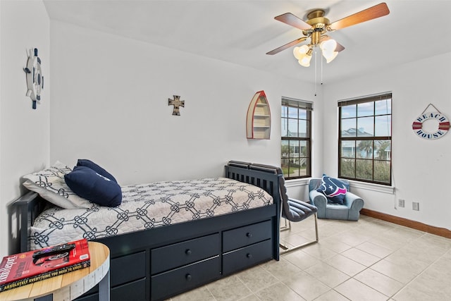 bedroom featuring light tile patterned floors, a ceiling fan, and baseboards