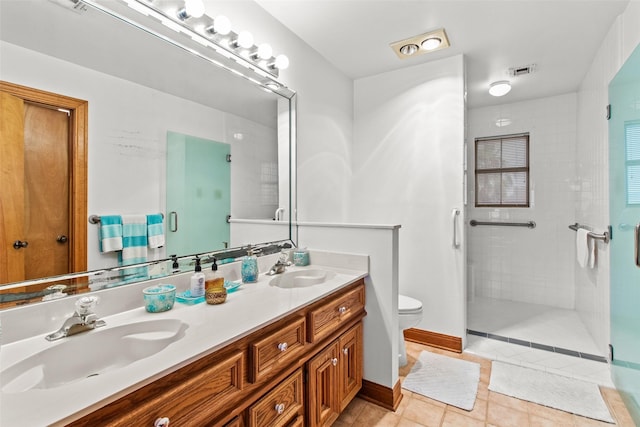 bathroom featuring toilet, a stall shower, and a sink