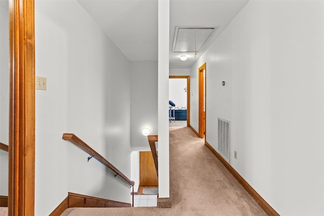 corridor featuring light carpet, visible vents, baseboards, an upstairs landing, and attic access