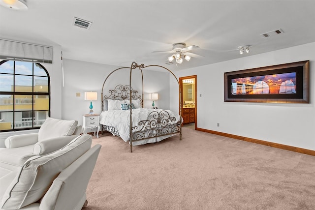 bedroom with visible vents, light carpet, baseboards, and ensuite bathroom