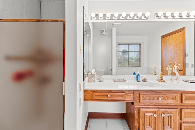 full bath with a stall shower, vanity, and tile patterned floors