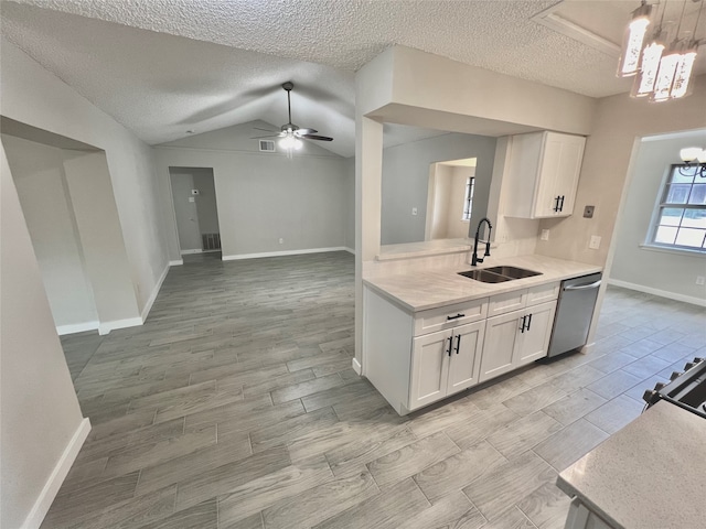 kitchen featuring dishwasher, white cabinetry, sink, and lofted ceiling